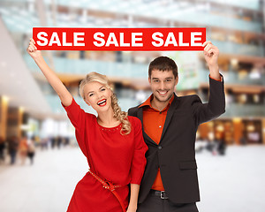 Image showing smiling couple with red sale sign