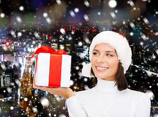 Image showing smiling woman in santa helper hat with gift box