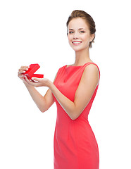 Image showing smiling young woman in red dress with gift box