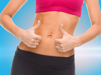 Image showing close up of female abs and hands showing thumbs up