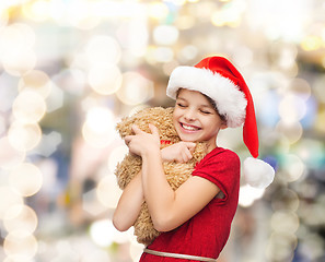 Image showing smiling girl in santa helper hat with teddy bear