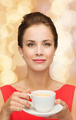 Image showing smiling woman in red dress with cup of coffee