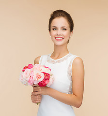 Image showing smiling woman in white dress with bouquet of roses