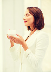 Image showing businesswoman with cup of coffee in office