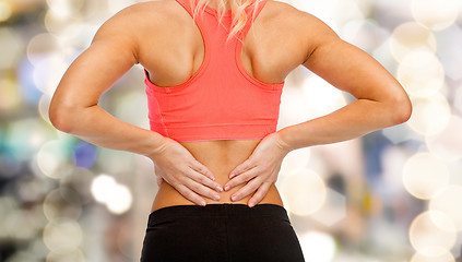 Image showing close up of sporty woman touching her back