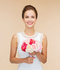 Image showing smiling woman in white dress with bouquet of roses