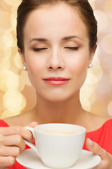 Image showing smiling woman in red dress with cup of coffee