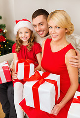 Image showing smiling family holding many gift boxes