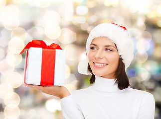 Image showing smiling woman in santa helper hat with gift box