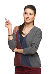 Image showing Woman in cardigan pointing at blank copy space