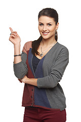 Image showing Woman in cardigan pointing at blank copy space