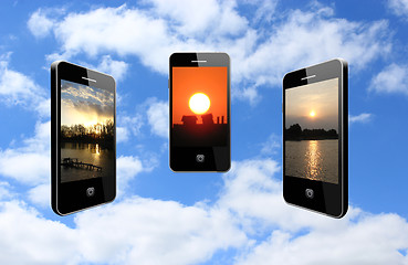 Image showing three mobile phones with different sunsets