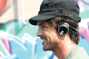 Image showing guy listening to player in earphones e