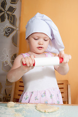 Image showing baby girl in cook role on kitchen