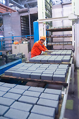 Image showing Worker at machine on stone blocks drying