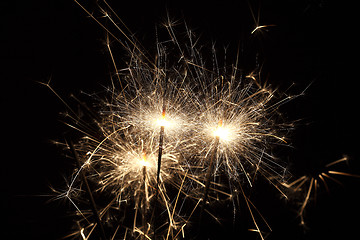 Image showing Burning sparklers on black background