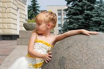 Image showing Small girl near a marble ball in a summer day