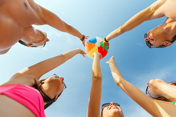 Image showing smiling friends in circle on summer beach