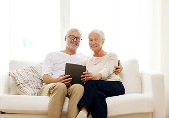 Image showing happy senior couple with tablet pc at home