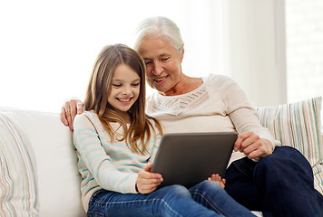 Image showing smiling family with tablet pc at home