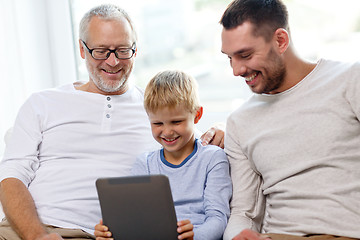 Image showing smiling family with tablet pc at home