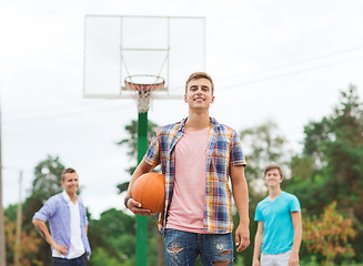 Image showing group of smiling teenagers playing basketball