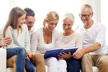 Image showing happy family with book or photo album at home