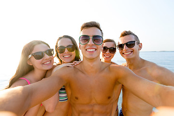 Image showing group of smiling friends making selfie on beach