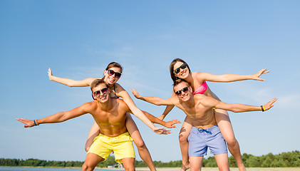 Image showing smiling friends having fun on summer beach