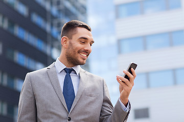 Image showing smiling businessman with smartphone outdoors