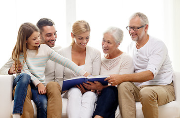 Image showing happy family with book or photo album at home