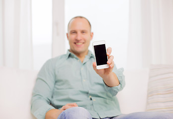 Image showing close up of smiling man with smartphone at home