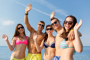 Image showing smiling friends in sunglasses on summer beach