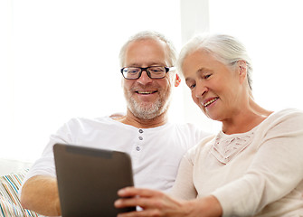 Image showing happy senior couple with tablet pc at home