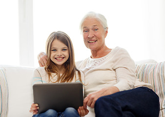 Image showing smiling family with tablet pc at home