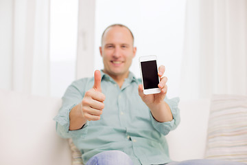 Image showing close up of smiling man with smartphone at home