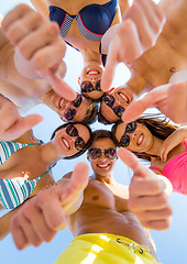 Image showing smiling friends showing thumbs up in circle