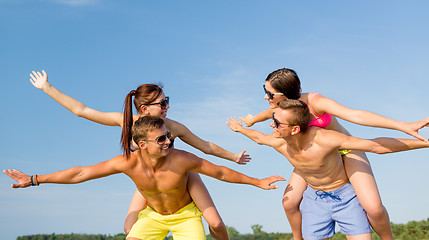 Image showing smiling friends having fun on summer beach