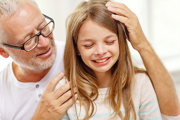 Image showing grandfather with crying granddaughter at home