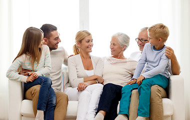 Image showing happy family sitting on couch at home