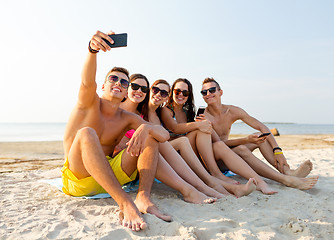 Image showing friends with smartphones on beach