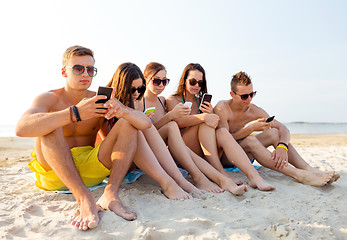 Image showing group of friends with smartphones on beach