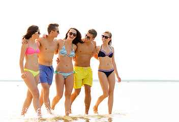 Image showing smiling friends in sunglasses on summer beach