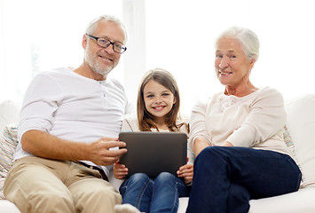 Image showing smiling family with tablet pc at home