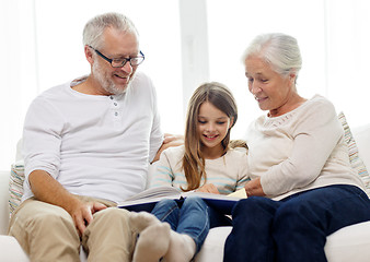 Image showing smiling family with book at home