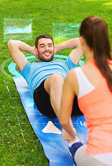 Image showing smiling couple doing exercises on mat outdoors