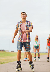 Image showing group of smiling teenagers with roller-skates