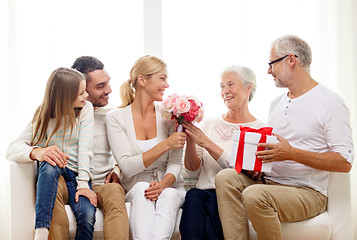 Image showing happy family with bunch and gift box at home