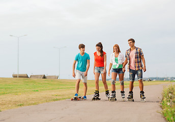 Image showing group of smiling teenagers with roller-skates