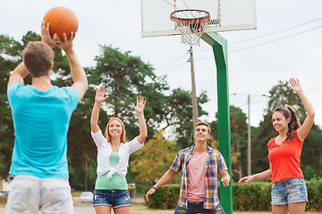 Image showing group of smiling teenagers playing basketball